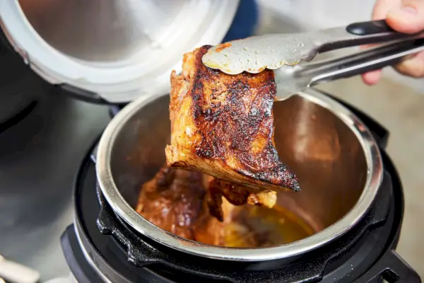 Pessoa fritando carne na Panela de Pressão Multiuso Instant Pot Duo Mini 3-Quart V5
