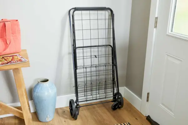 벽에 접힌 Amazon Basics 접이식 쇼핑 유틸리티 카트