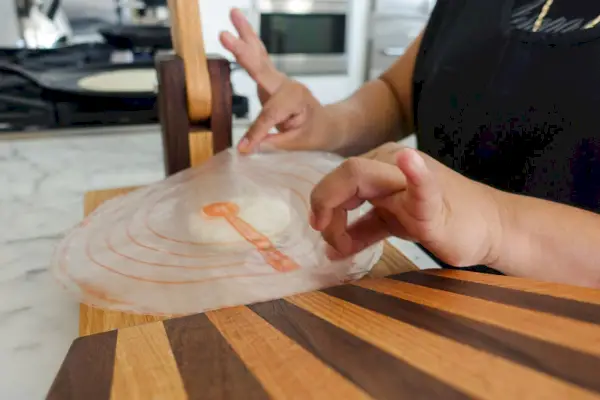 Osoba používajúca lis na tortilla z tvrdého dreva Central Coast Woodworks