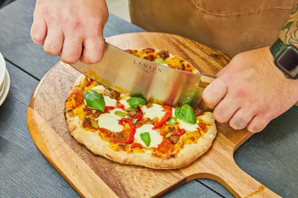 Osoba krojąca ciasto wykonane w piecu do pizzy Alfa Forni Moderno 2