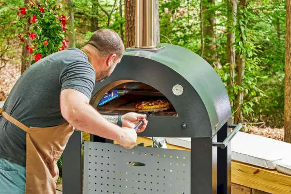 Osoba wkładająca pizzę do pieca do pizzy Alfa Forni Moderno 2