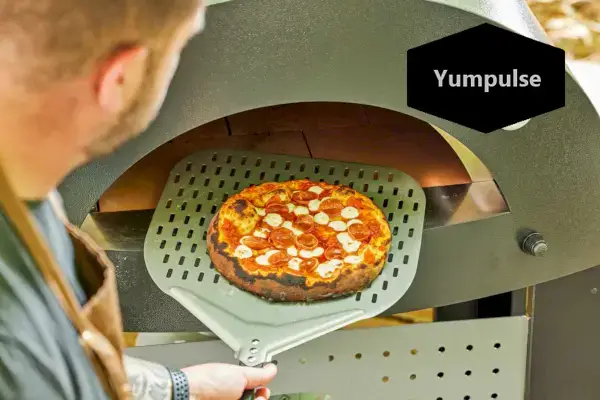 Osoba wyjmująca ciasto z pieca do pizzy Alfa Forni Moderno 2