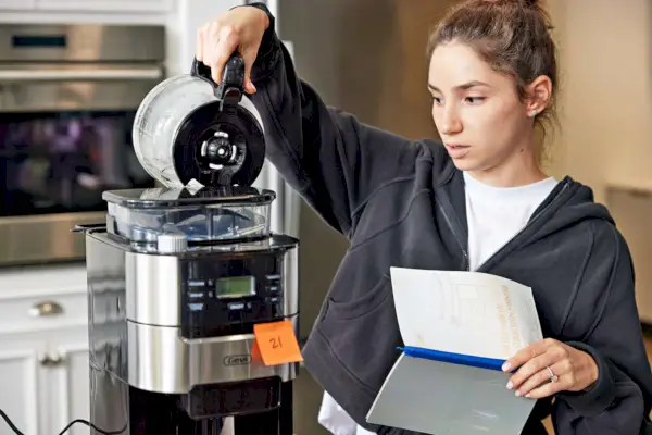 Person gießt Wasser in eine 10-Tassen-Filterkaffeemaschine von Gevi