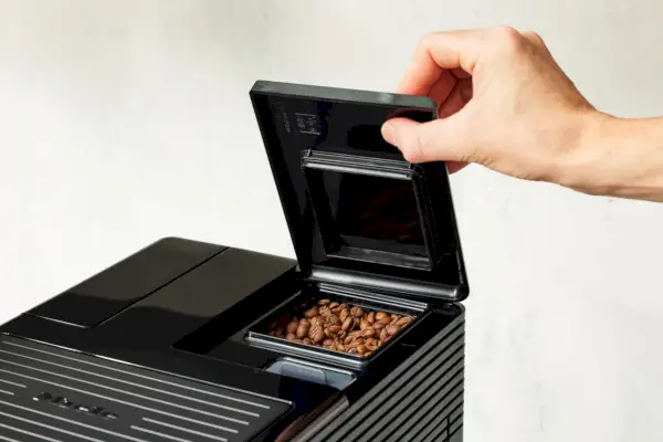Öffnen Sie mit der Hand den Deckel der automatischen Kaffeemaschine und Espressomaschine Miele Silence