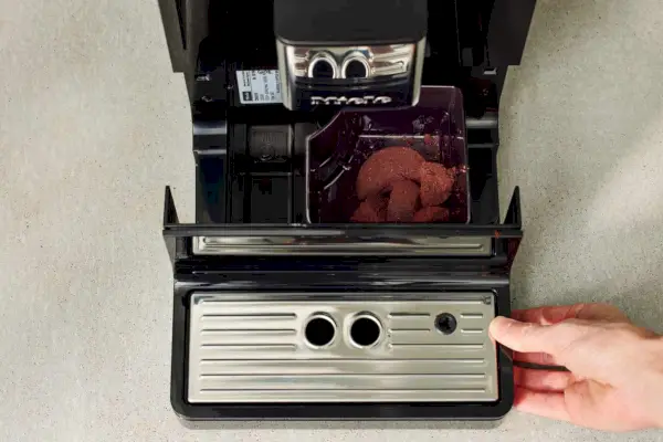 Herausziehen der Ablage/Abtropffläche der automatischen Kaffee- und Espressomaschine Miele CM 5310 Silence mit der Hand