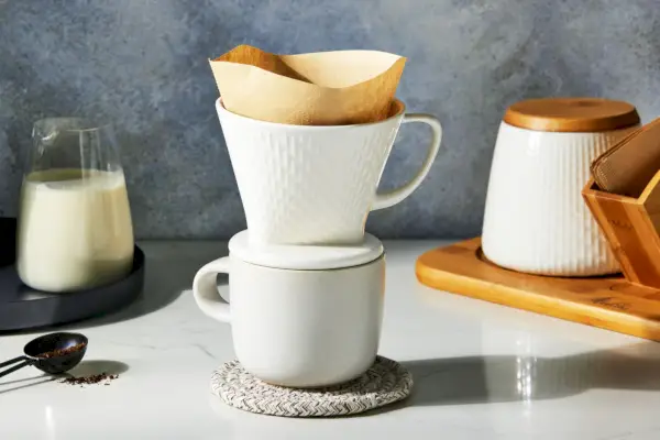 O conjunto de cafeteira e vasilha Melitta Artisan Porcelain Pour-Over é exibido no balcão