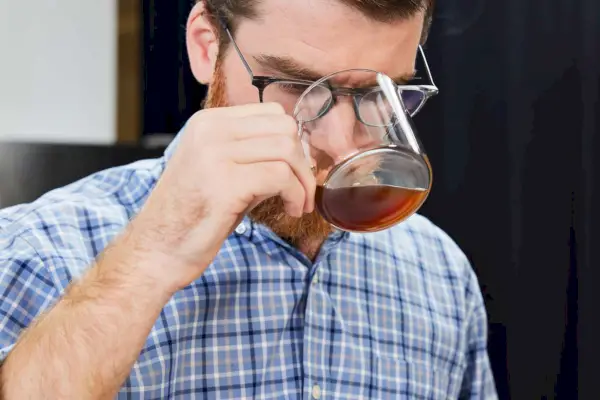 Pessoa bebendo café feito com conjunto de cafeteira Coffee Gator Paperless Pour Over