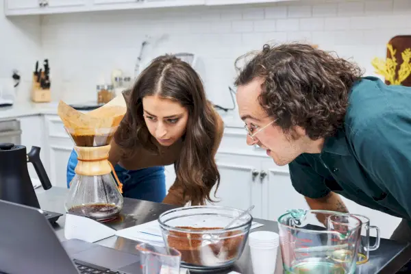 Duas pessoas assistindo café sendo feito na cafeteira Chemex Classic Series
