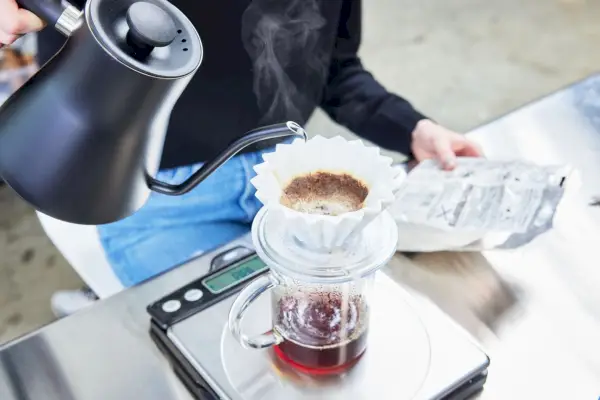 Pessoa derramando água no gotejador de café Origami Japan Pour Over Coffee