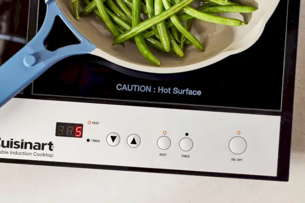Grüne Bohnen kochen in einer Pfanne auf dem 12-Zoll-Glas-Doppel-Induktionskochfeld Cuisinart ICT-60