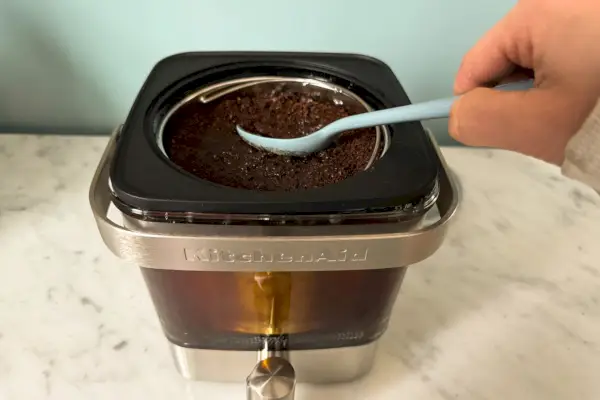 O café moído é colocado na cafeteira KitchenAid KCM4212SX de 28 onças Cold Brew