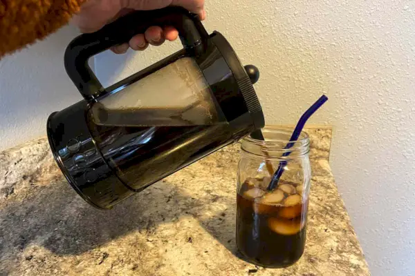 Uma pessoa derrama café frio da cafeteira Bodum Bean Cold Brew em um frasco de vidro