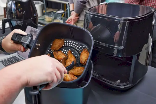 Alitas de pollo saliendo de la freidora