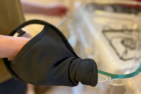 Halten Sie mit der Hand einen OXO Good Grips Silikon-Topfhalter, um eine Glasschale zu halten