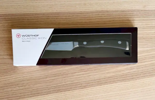 Wusthof Classic Ikon Paring Knife는 나무 테이블 위의 상자에 표시되어 있습니다.