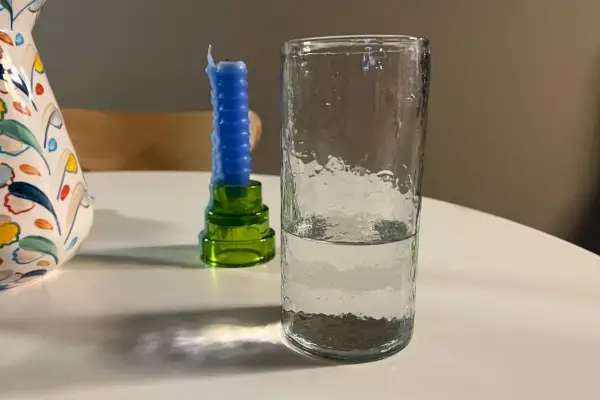Il bicchiere d'acqua alto martellato artigianale Pottery Barn su un tavolo bianco