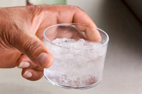 Una persona tiene in mano un set tumbler in vetro Bormioli Rocco Bodega Mini da 7,5 once riempito con acqua ghiacciata