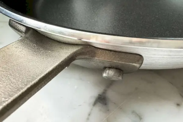 Eine Nahaufnahme des Griffs der professionellen 10-Zoll-Restaurant-Bratpfanne aus Aluminium mit Antihaftbeschichtung von Tramontina