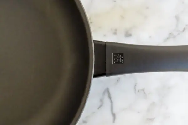 Eine Nahaufnahme des Griffs der Zwilling Madura Plus 11-Zoll-Antihaft-Aluminium-Frittierpfanne