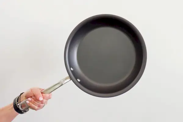 Eine Person hält die 10-Zoll-Antihaft-Bratpfanne von Made In Cookware hoch