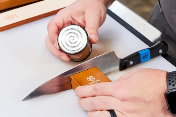 אדם משתמש ב-Tumbler The Original Rolling Knife Sharpener כדי להשחיז סכין