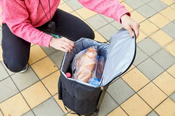 Persona che apre la cerniera superiore per rivelare il cibo all'interno del frigorifero ultra compatto dbest Products