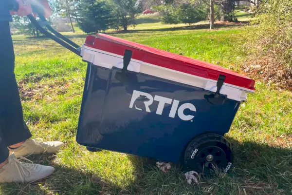 Una persona che trasporta il frigorifero portatile ultraleggero RTIC 52 QT