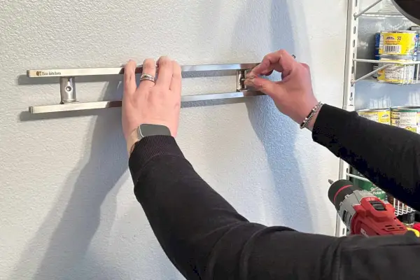 מישהו שם מחזיק סכין מגנטי למטבח אקולוגי על קיר לבן