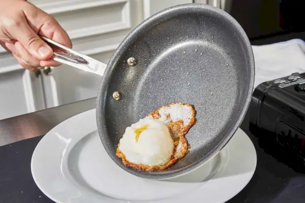 Ein Ei wird in der All-Clad D3 Edelstahl-Pfanne mit dreilagigem, 10-teiligem, antihaftbeschichtetem Kochgeschirr-Set gekocht