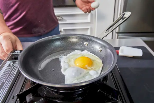 Ein Ei wird in der All-Clad D3 Edelstahl-Pfanne mit dreilagigem, 10-teiligem, antihaftbeschichtetem Kochgeschirr-Set gekocht