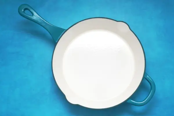 Crock Pot Artisan Gusseisenpfanne auf blauem Hintergrund