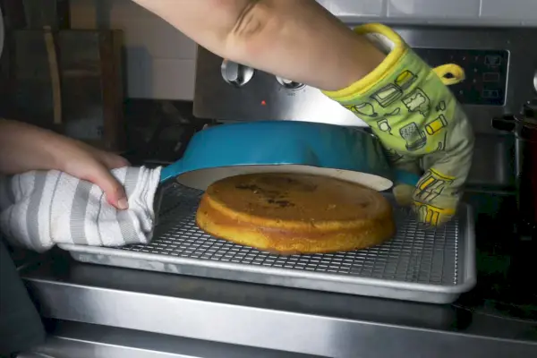 Eine Person nimmt Kuchen aus der Gusseisenpfanne von Crock Pot Artisan