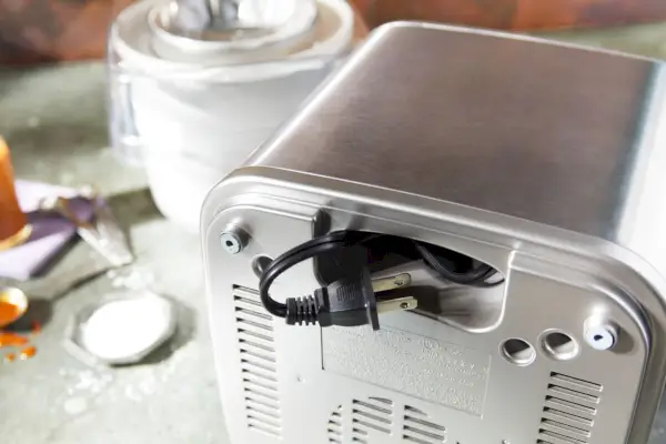 Detailný záber na zástrčku a kábel zastrčený v zadnej časti Cuisinart Pure Indulgence 2 Qt. Výrobník zmrzliny