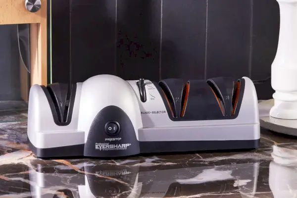 משחיז סכינים חשמליים מקצועיים Presto 08810 מוצג על משטח שיש שחור ולבן