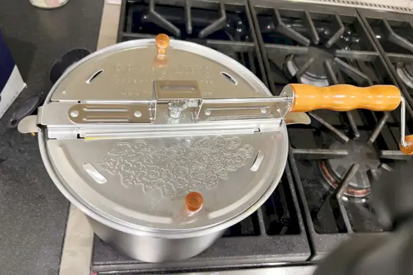 מכונת הפופקורן המקורית של כיריים Whirley Pop של Franklin יושבת על גבי כיריים.