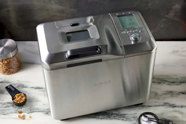 材料の隣の大理石のカウンターにある Breville Custom Loaf Bread Maker