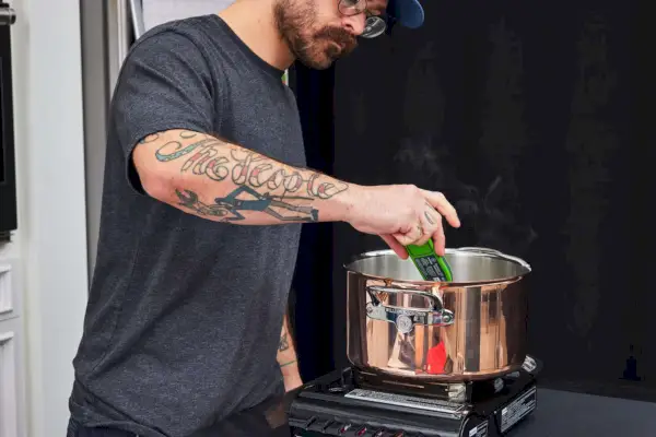 Eine Person überprüft die Temperatur im Topf des Williams Sonoma Thermo-Clad Copper 10-teiligen Kochgeschirr-Sets