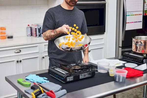 Eine Person kocht Essen in der 10-teiligen Pfanne aus Thermo-Clad-Kupfer-Kochgeschirr von Williams Sonoma