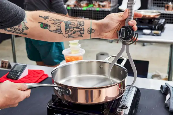 Eine Person untersucht das 10-teilige Kochgeschirrset Williams Sonoma Thermo-Clad Copper