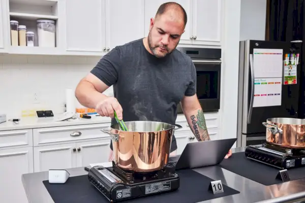 Eine Person misst die Temperatur im Topf des Viking 4-Ply Contemporary 9-Piece Copper Cookware Set