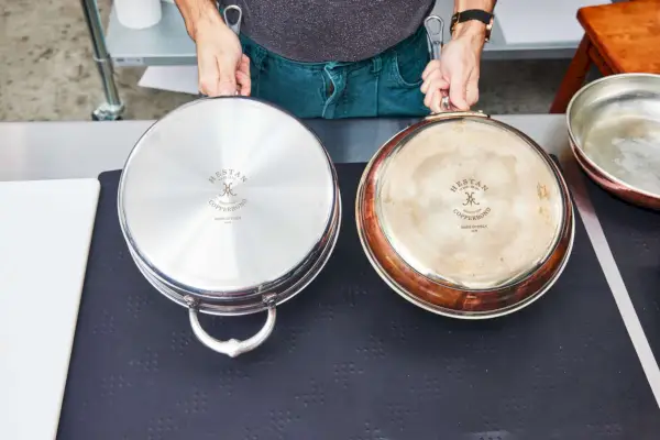 Eine Person hält den Boden der 10-teiligen Kochgeschirr-Set-Pfanne von Hestan CopperBond hoch