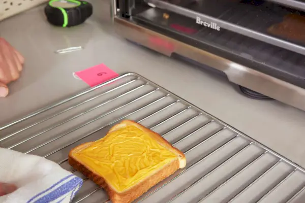 Breville The Compact Smart Oven の隣のカウンターに陳列されたトレイに置かれたチーズ トースト
