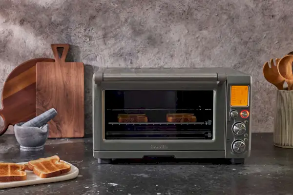 キッチン用品の隣の黒いカウンタートップに置かれた Breville スマート オーブン エアフライヤー