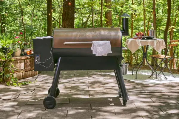 Traeger Timberline Wood Pellet Grill의 측면 버너에 있는 다이얼을 돌리는 사람