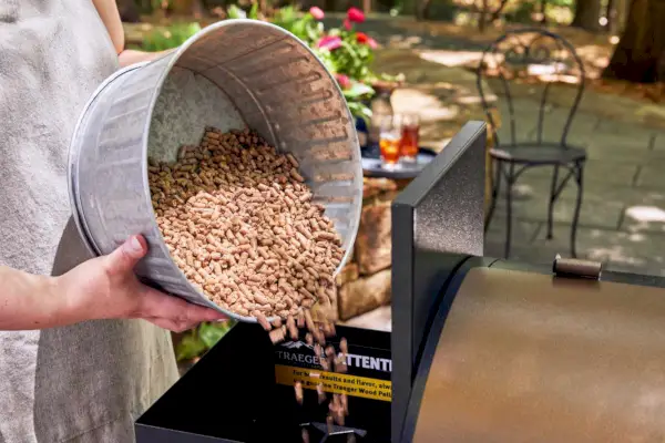 Traeger Timberline Pellet Grill에서 닭 날개를 요리하는 사람