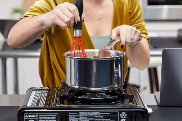 osoba mieszająca wewnątrz Le Creuset Tri-Ply Stal nierdzewna 10 szt. Zestaw naczyń kuchennych