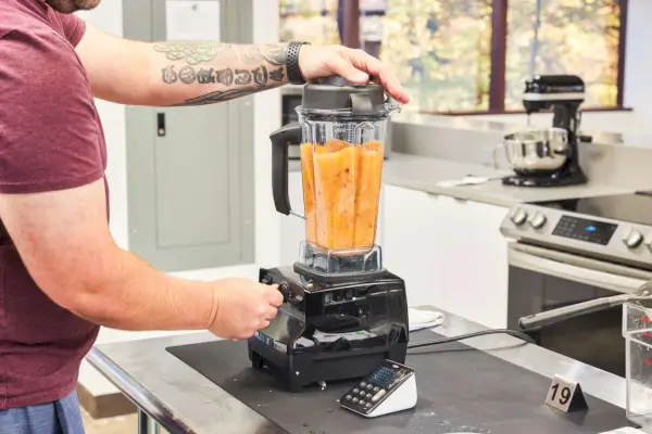 אדם הממזג מזון בבלנדר Vitamix 5200 Professional Grade
