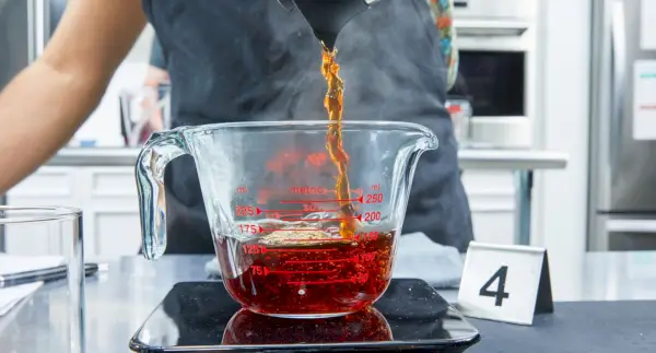 Café feito de BALMUDA The Brew sendo servido em um copo medidor