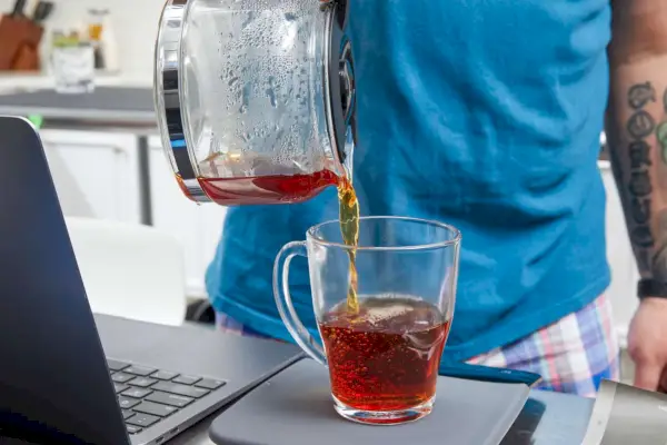 Café preparado com cafeteira Krups Simply Brew de aço inoxidável, 5 xícaras, sendo derramado em copo de vidro