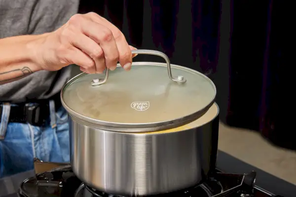 Eine Person kocht mit der Pfanne aus dem 10-teiligen Kochgeschirrset GreenLife Stainless Pro